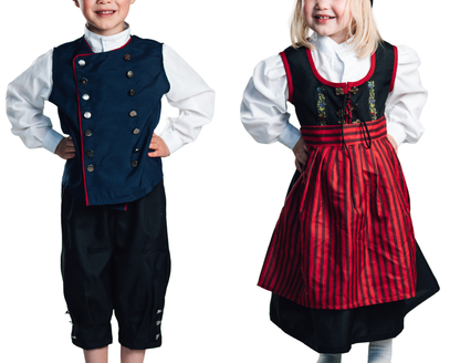 Lítill drengur í fallegum barnabúningi fyrir tyllidaga og stúlka í hátíðarbúning fyrir 17.júní